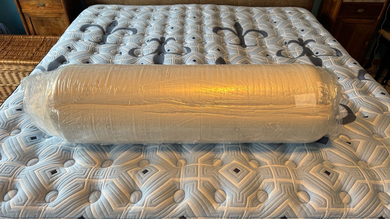 The Naturepedic Adagio 2" Organic Latex Mattress Topper rolled up in plastic