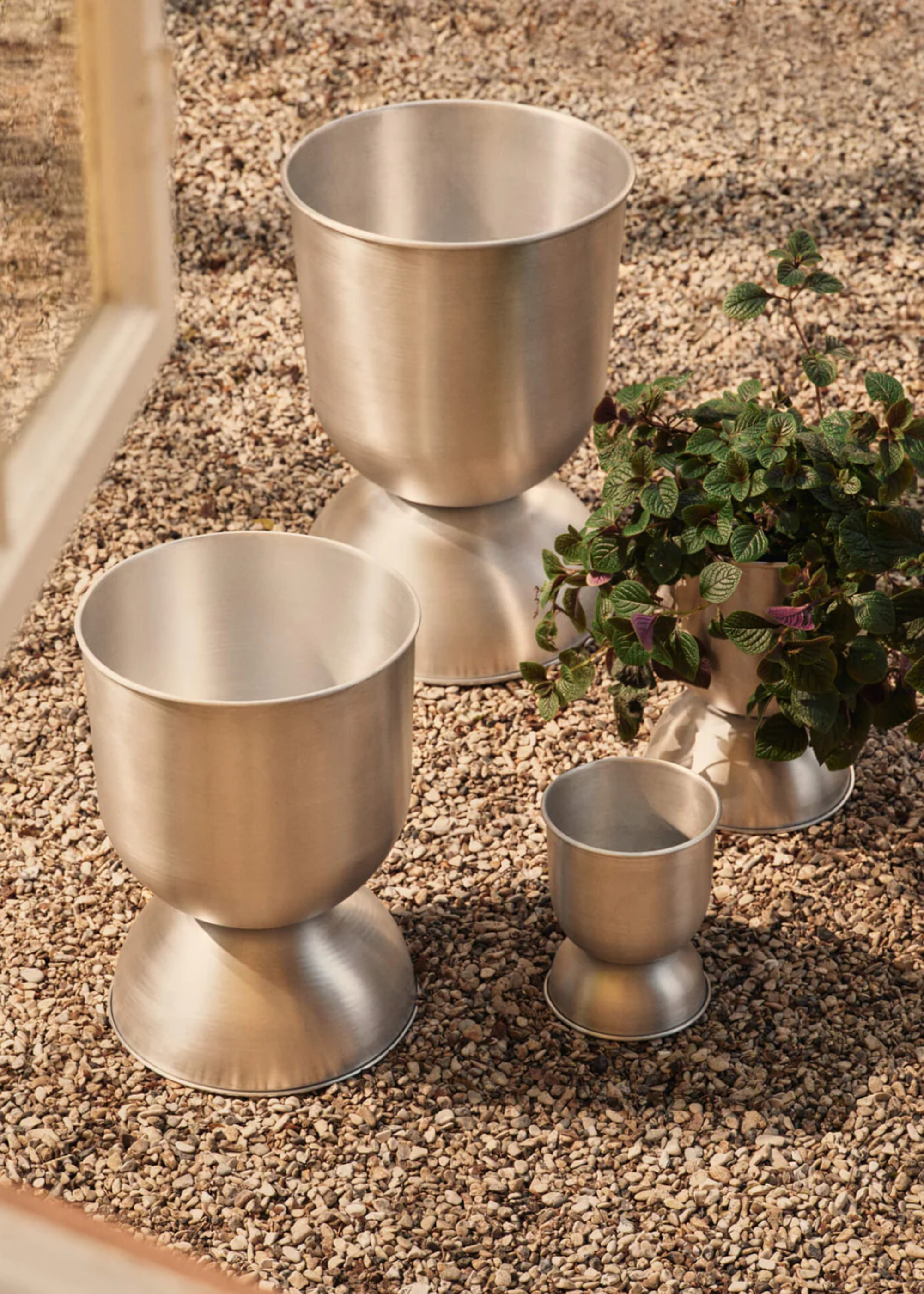 A set of brushed silver planters