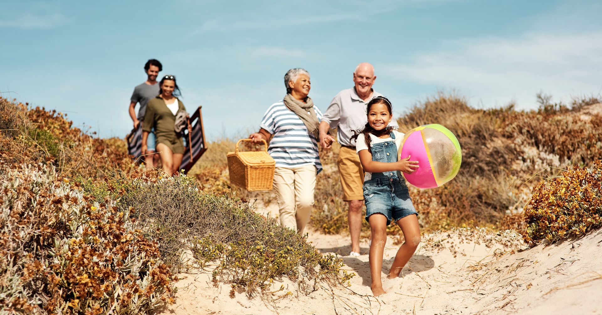 Shot of an adorable little girl having a fun day at the beach with her parents and grandparents