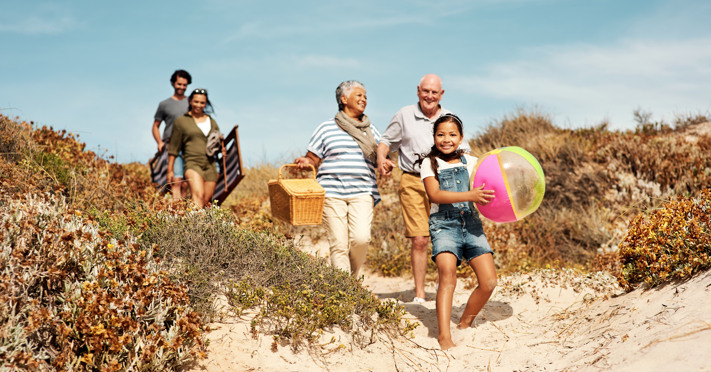 Shot of an adorable little girl having a fun day at the beach with her parents and grandparents