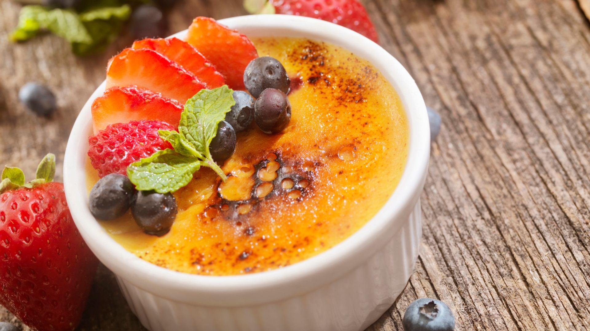 An individual creme brûlée with fruit on top