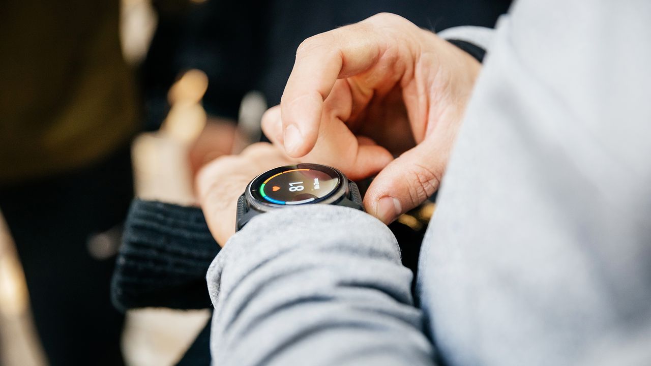 Close-up hands of a man using smartwatch after exercise, midsection