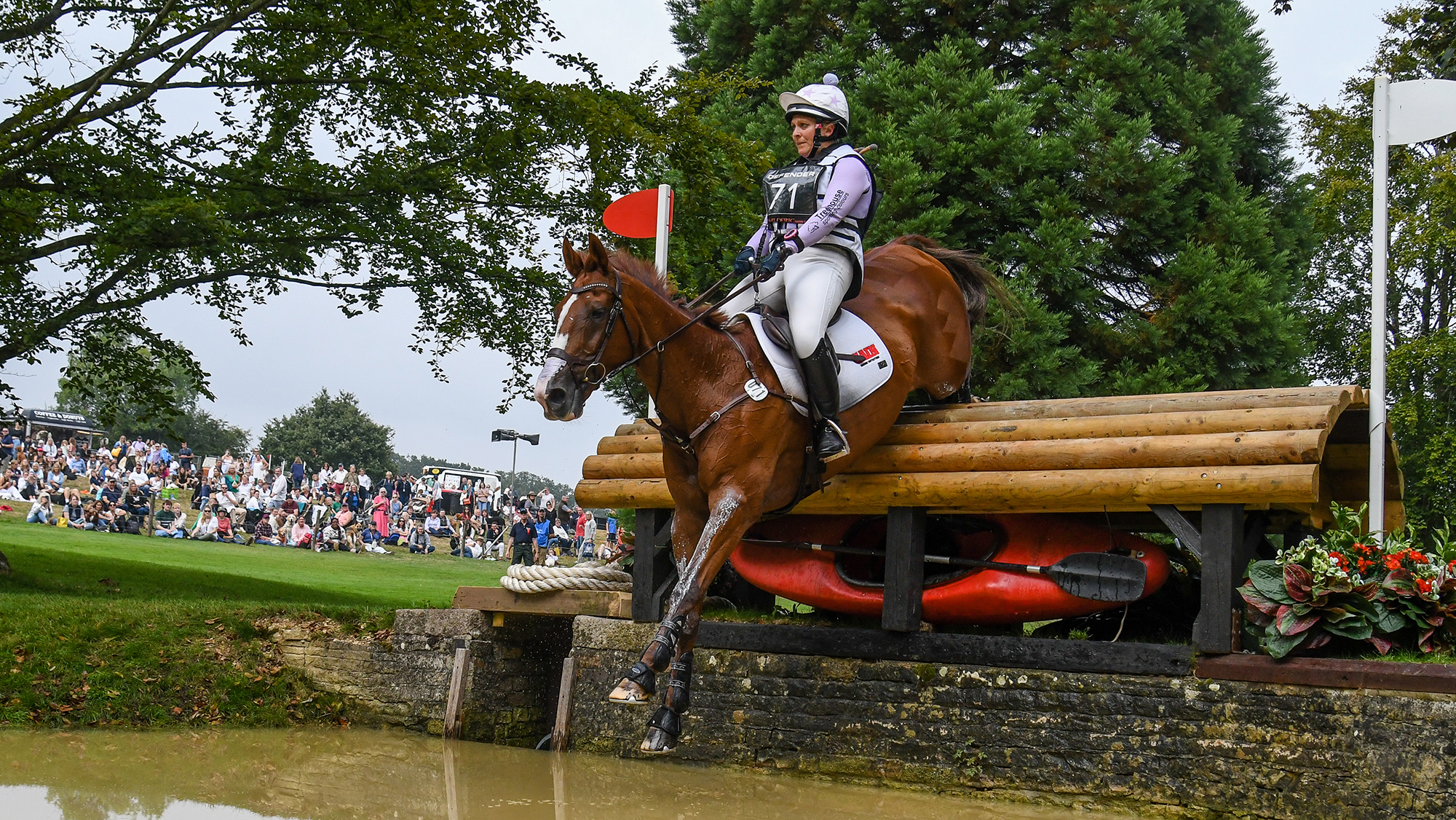 Gemma Stevens jumps a solid log fence into water on her horse Chilli Knight