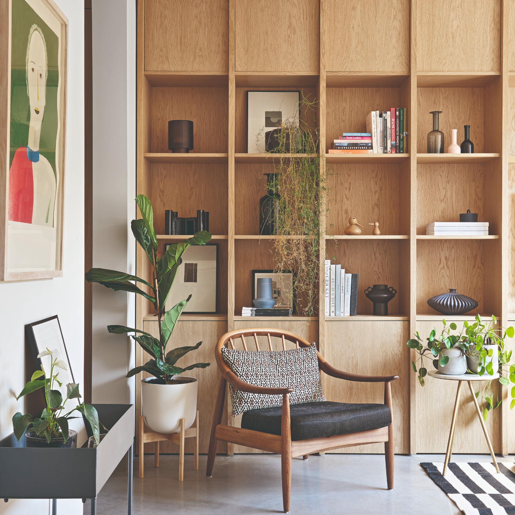 A living room with built-in bookshelves styled with books, vases, small artworks and decorative objects
