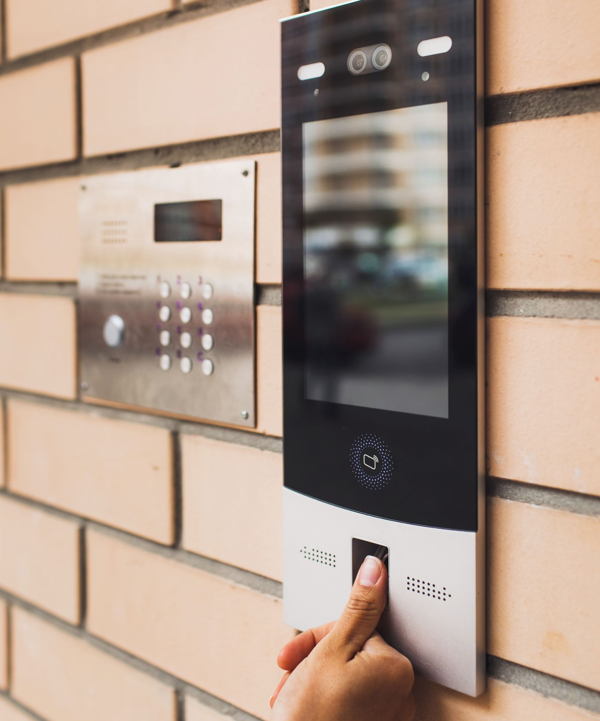 A black fingerprint home entry security system on a wall with silver metal trim