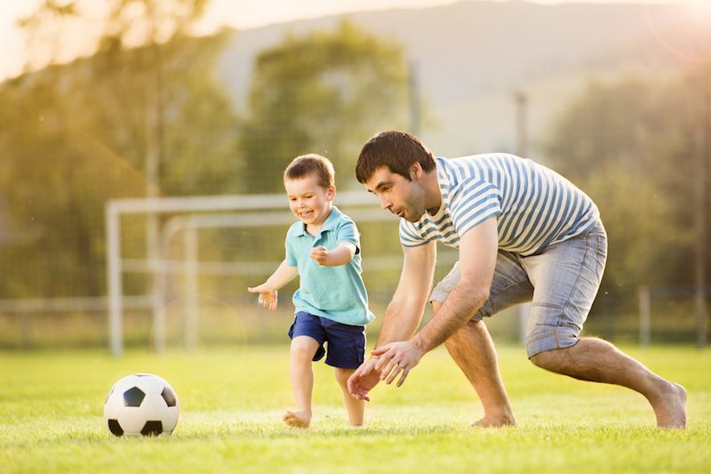 father and son playing soccer