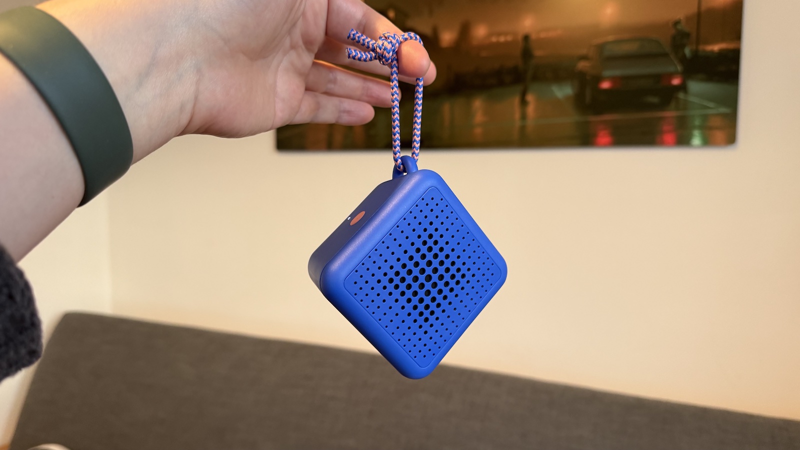 A small, Blue Ikea speaker, photographed in someone's hand