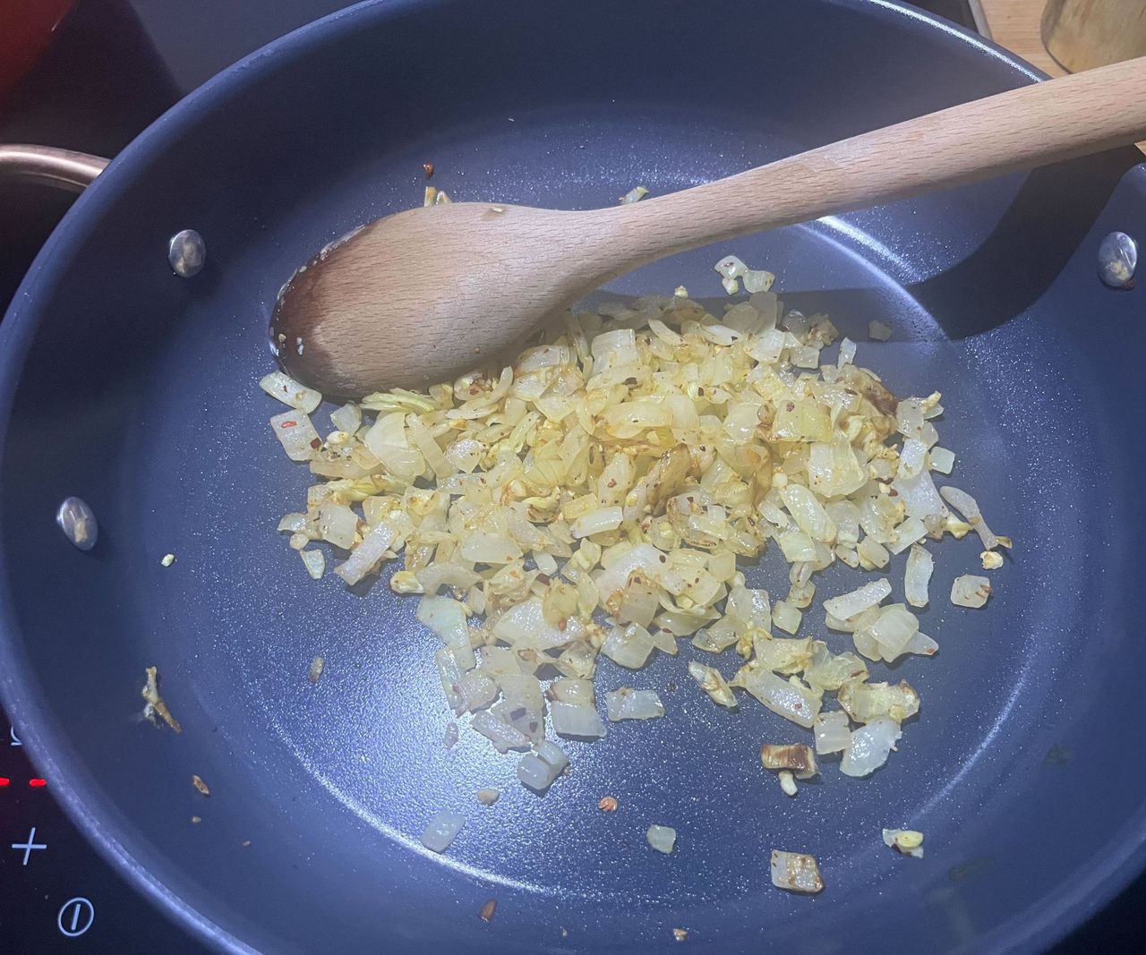 Onions caramelizing in a blue ceramic saute pan