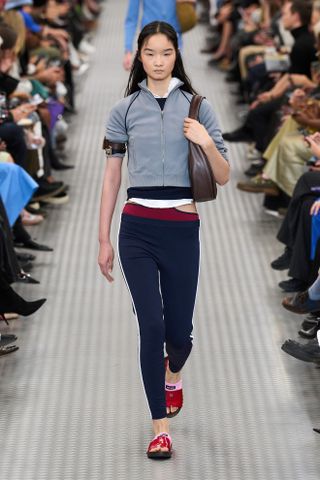 Model walking on the Miu Miu runway wearing skinny trousers.