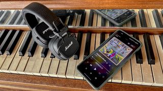 Marshall Major V headphones on piano keys with a smart device