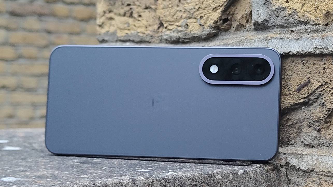 The OnePlus Nord 5 against a brick wall.