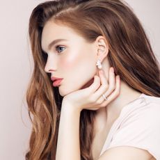 Studio shot of young beautiful woman with earrings and ring