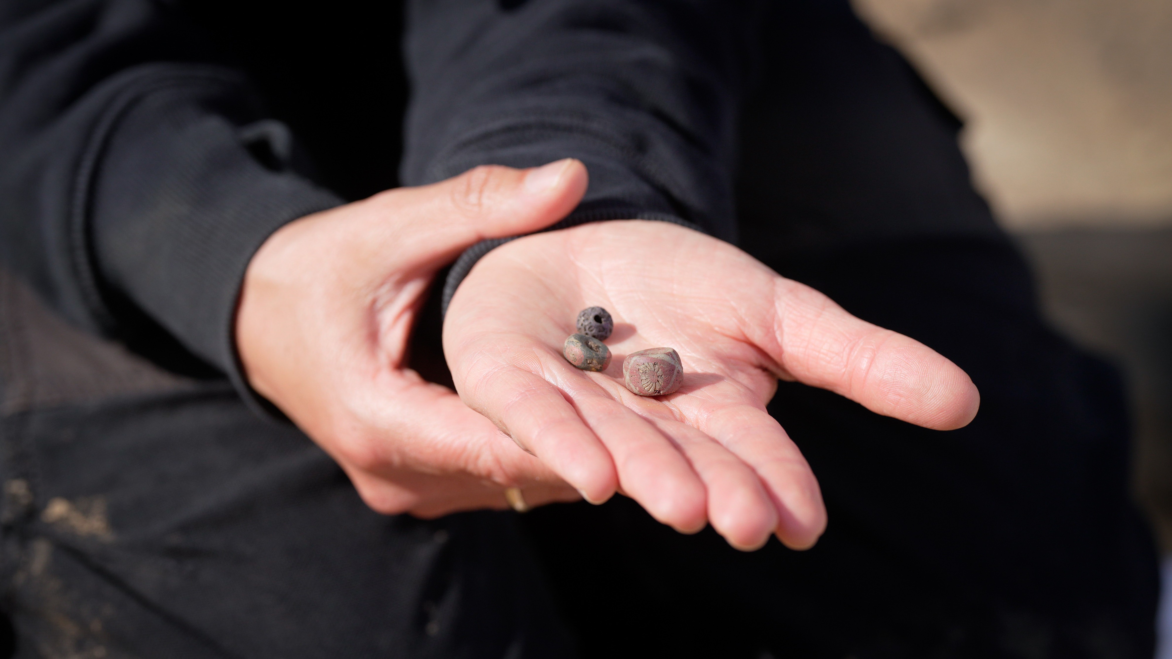 An outstretched hand shows three pearls.