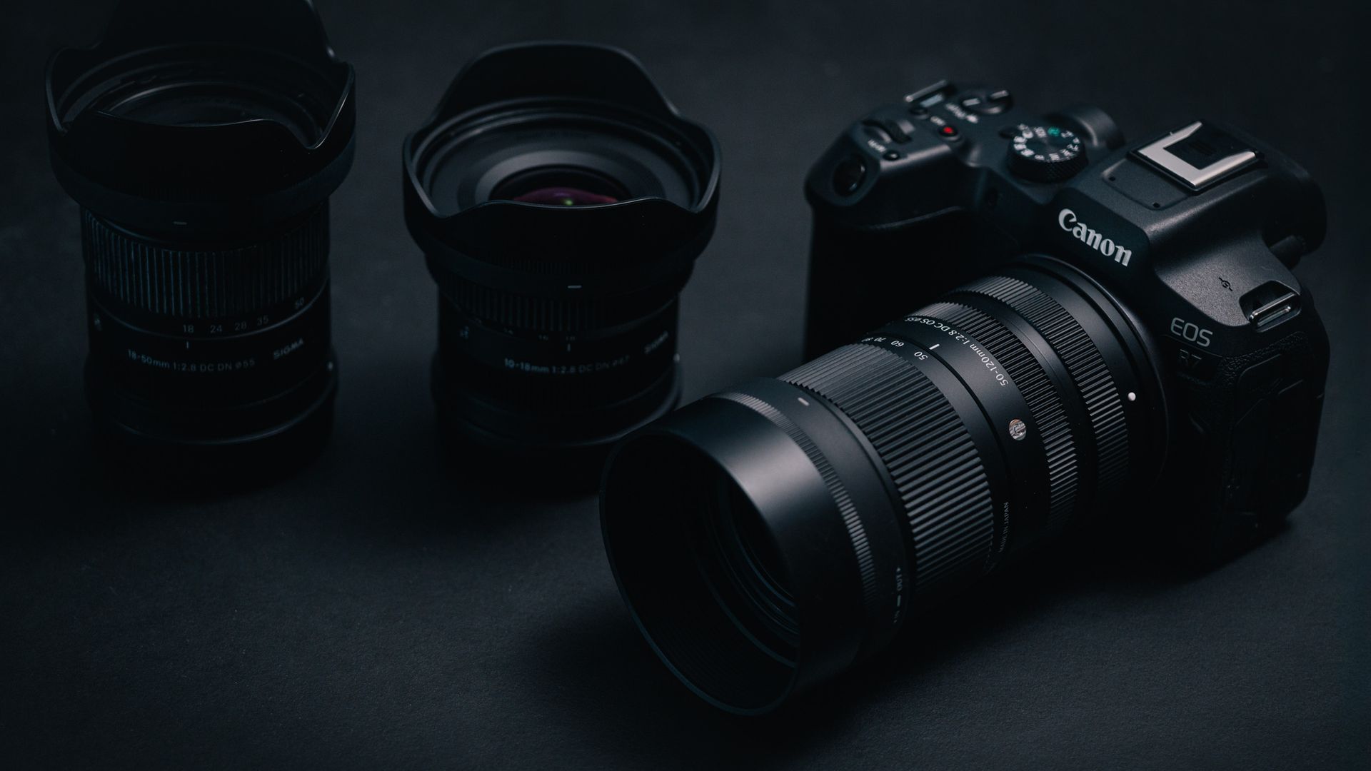 Sigma 50-120mm F2.8 DC OS Contemporary lens attached to a Canon EOS R7, in a lowkey lit studio with dark background