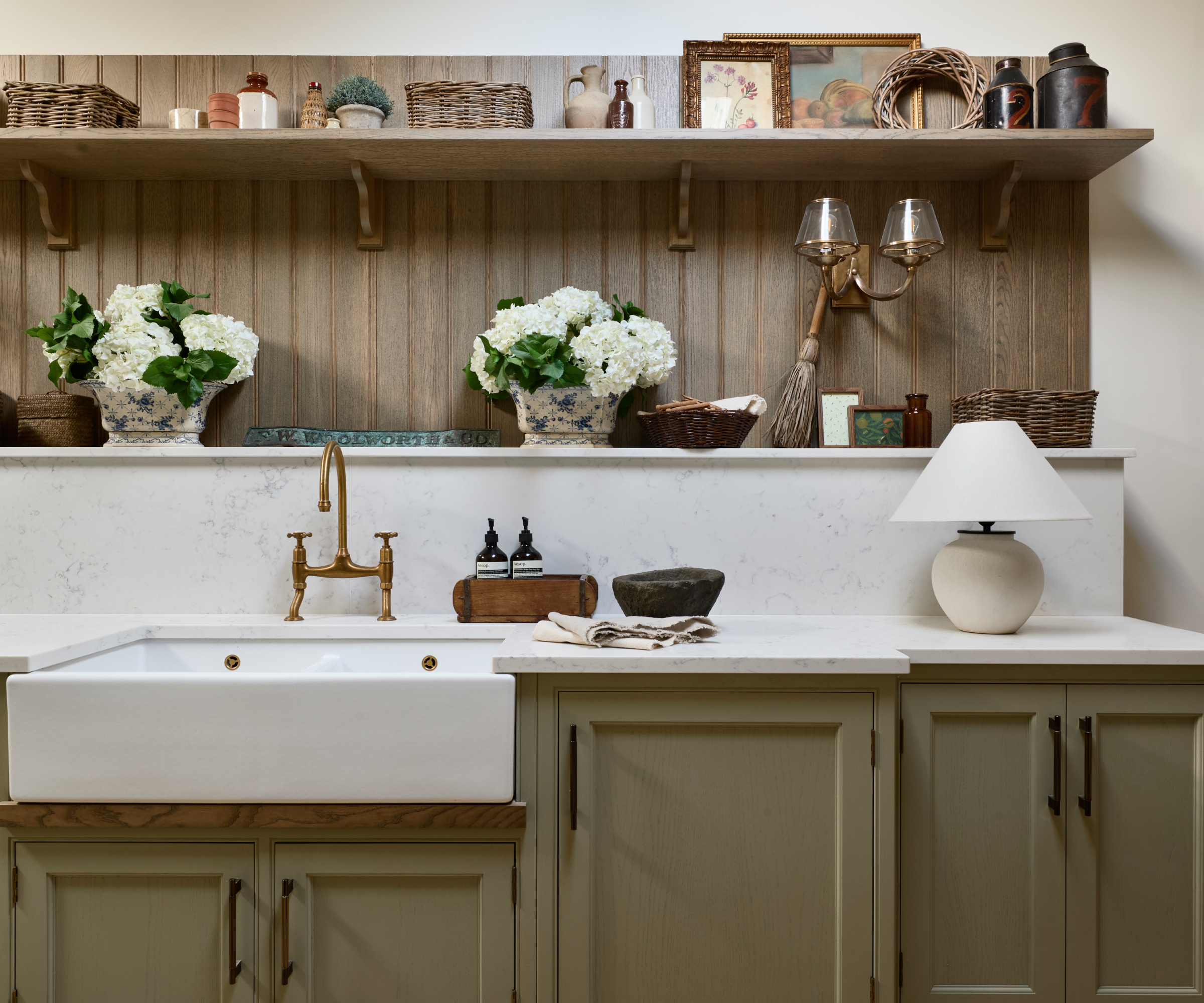galley kitchen with green cabinets, butler sink, black handles and open shelving above sink