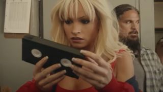 Lily James as Pam Anderson looks at a VHS tape.