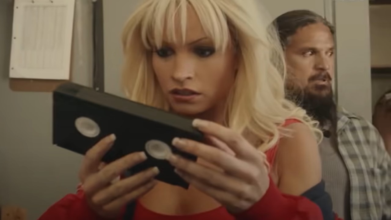 Lily James como Pam Anderson mira una cinta VHS.