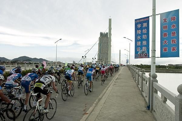 The peloton heads over a bridge in search of breakaway leader Stephan Cohnen (Continental Team Differdange).