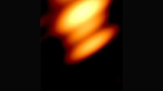 a blurry group of orange and yellow clouds of light on a black background