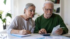 Senior Couple Calculating Household Expenses and Reviewing Bills at Home