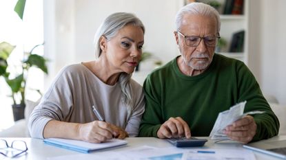 Senior Couple Calculating Household Expenses and Reviewing Bills at Home