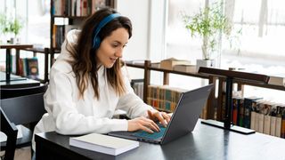 Woman playing games on Acer Chromebook 516 GE with headphones on