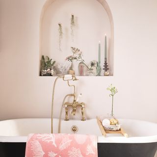 budget bathroom ideas with blush wall, black tub, storage in wall alcove