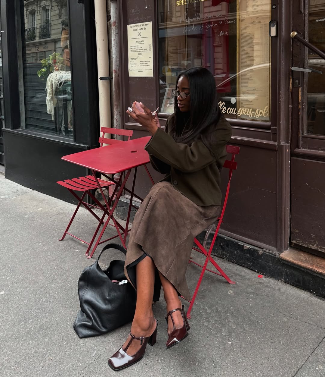 Liv in a brown suede skirt with a black leather tote