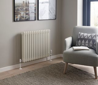 white column radiator in living room with blue armchair