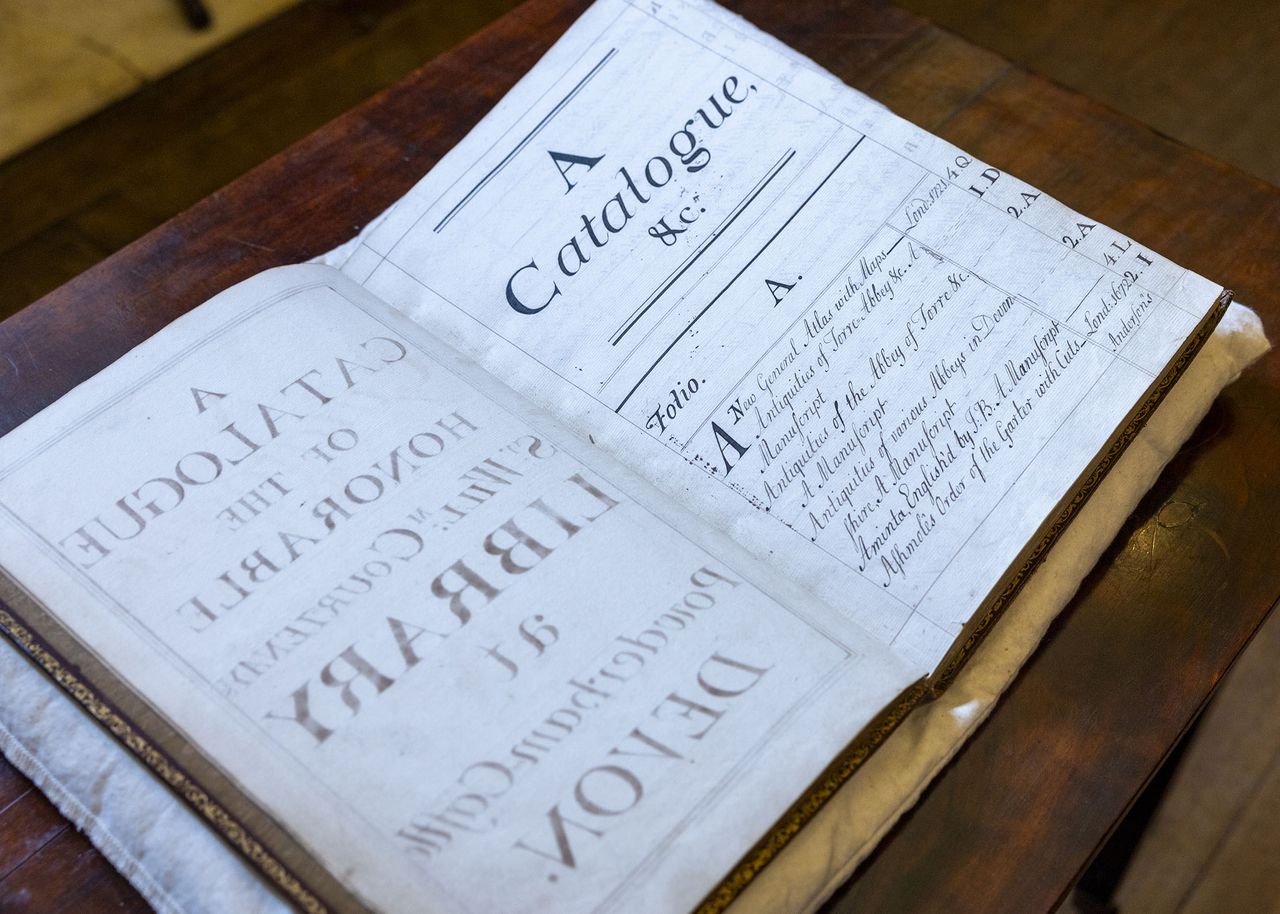 Charlie Courtenay, 19th Earl of Devon with his ancestor's book at Powderham Castle.