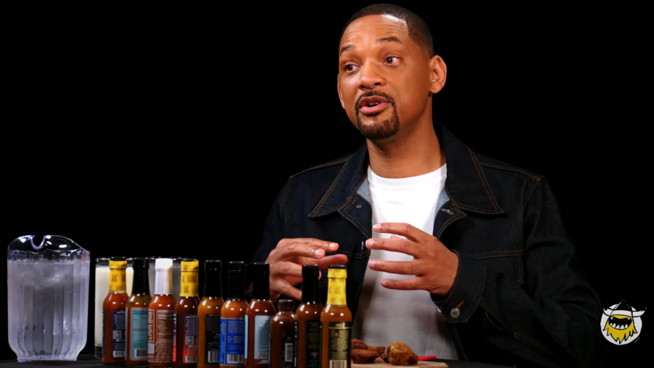 Will Smith habla sentado frente a una fila de salsas picantes y agua helada en Hot Ones.