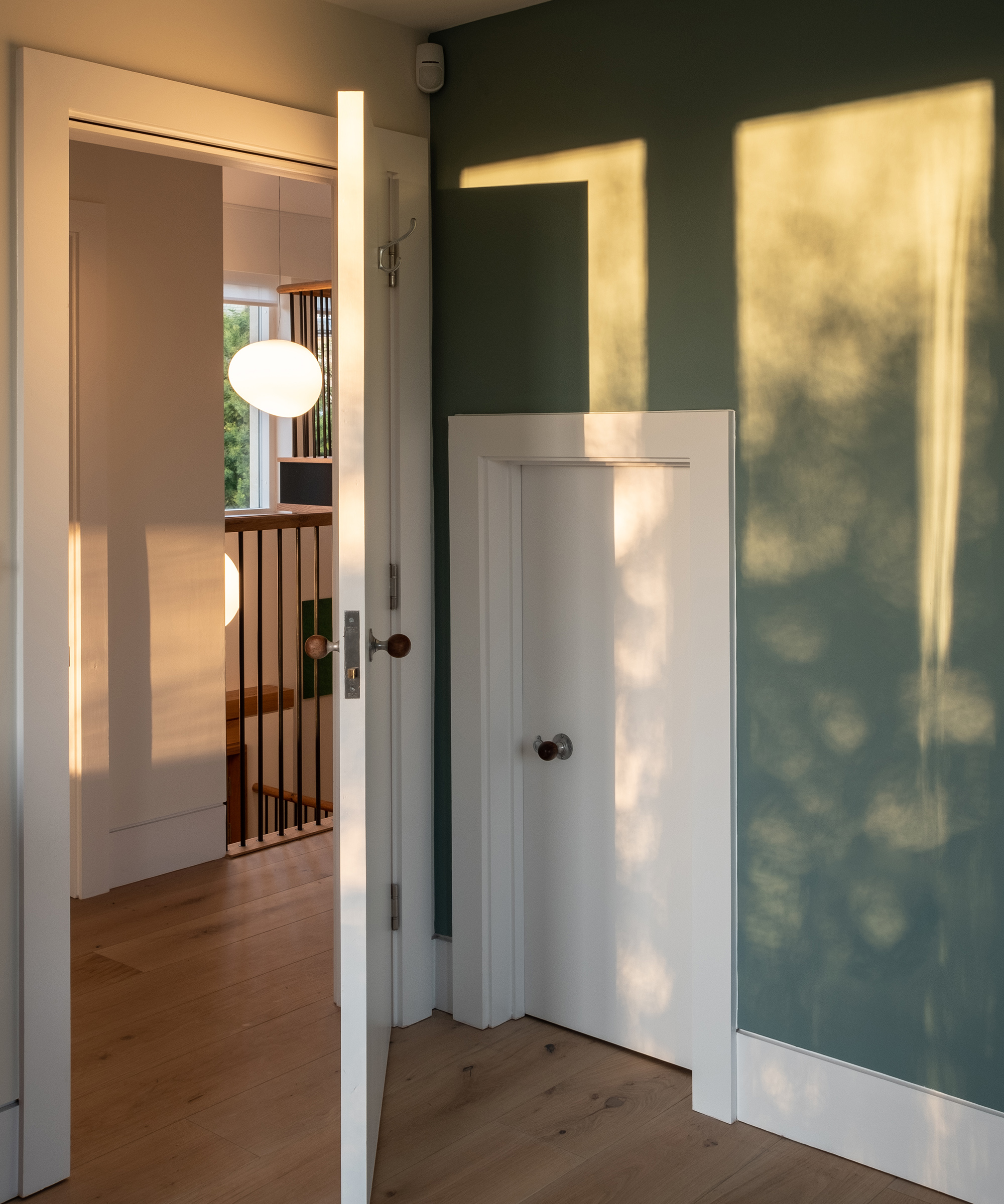 An open internal door looking out to a landing on a second floor