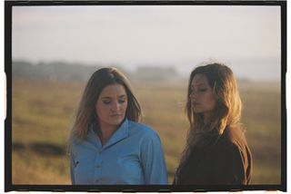 aj michalka and aly michalka standing in a field by the ocean