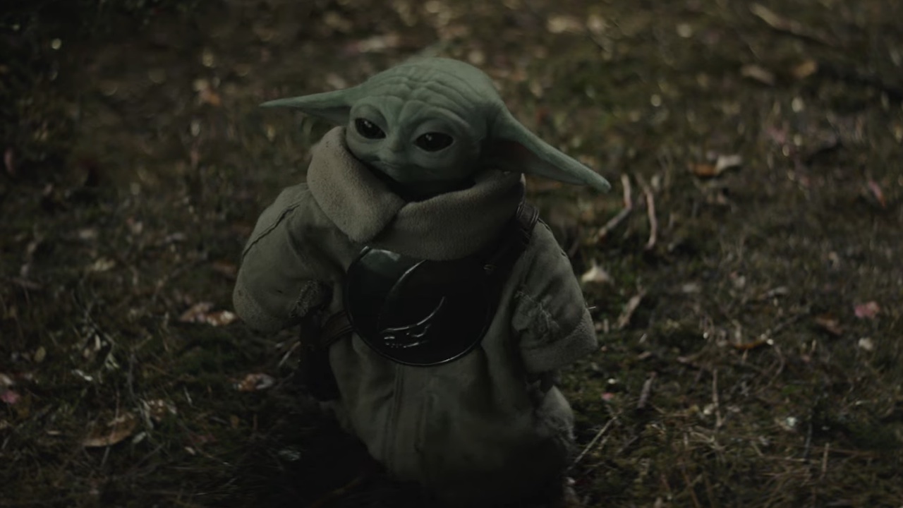 Grogu on the grass with his armor on.