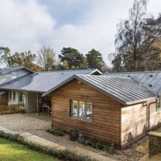 Bungalow on sloping site, with clad and rendered exterior