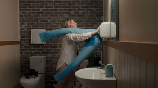 Bea drying her pants in the bathroom in Anyone But You