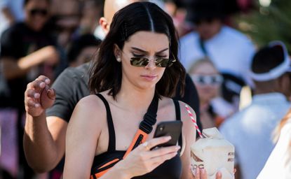 Kendall Jenner wearing cropped top, belt bag, military pants is seen at Revolve Festival on April 14, 2018 in Indio, California