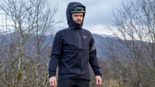 Rapha Trail GORE-TEX Infinium Jacket with the hood worn over a helmet