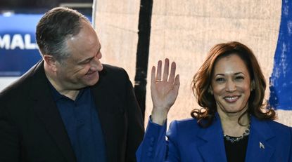 Vice President and Democratic presidential candidate Kamala Harris (R) waves to the audience alongside Second Gentleman Douglas Emhoff during a stop on their campaign bus tour in Rochester, Pennsylvania.