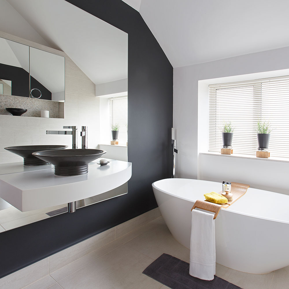 white bathroom with bathtub and black washbasin