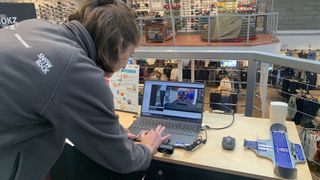 A running gait expert examines a runner's video on a laptop