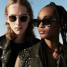 Two models wearing AllSaints sunglasses and leather jackets