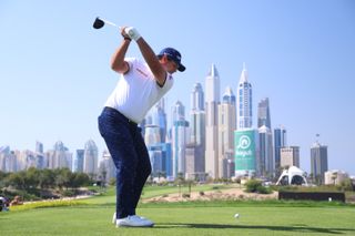 Reed hits a tee shot off the eight tee in Dubai
