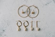 Various earrings of different shapes and designs on a white background