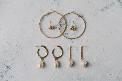 Various earrings of different shapes and designs on a white background