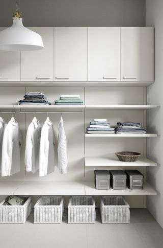 An example of utility room shelving ideas showing minimalist white shelving and storage units for fresh laundry