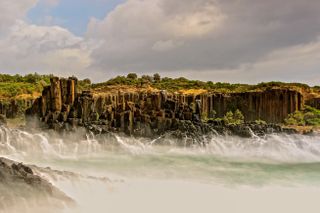Photo of waves crashing into quarried rock columns at Bombo Headland Quarry