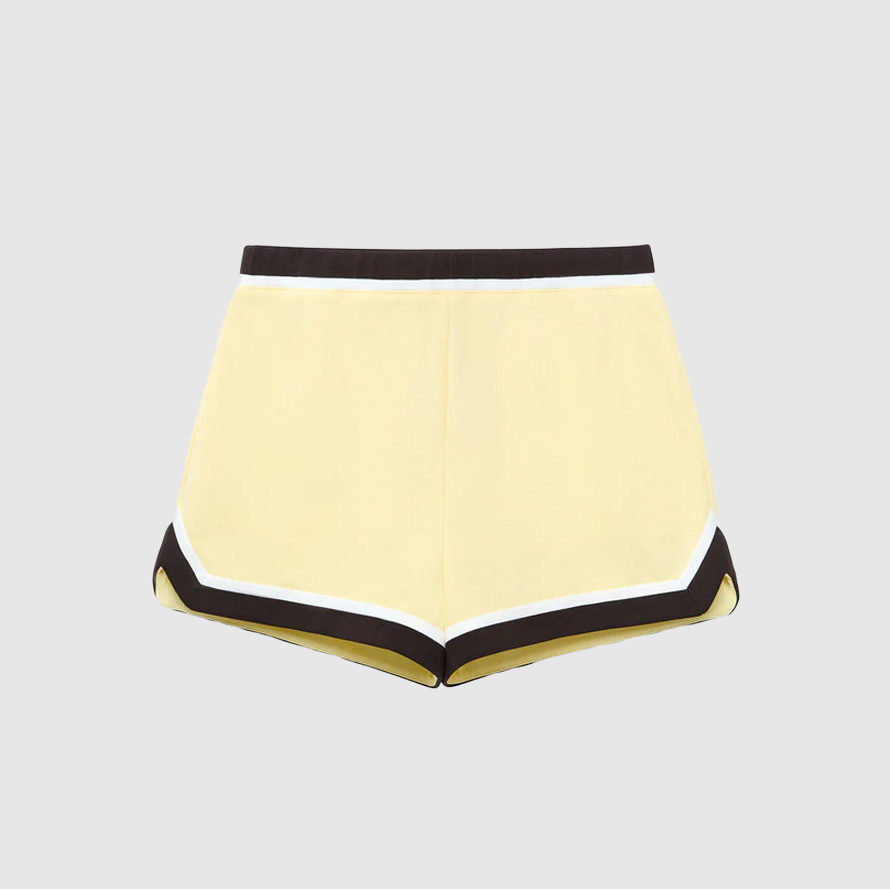 Butter yellow track shorts with black piping.