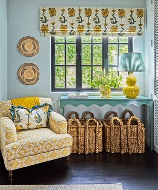 landing with pale blue walls, wooden floor, yellow patterned armchair and blinds and blue console