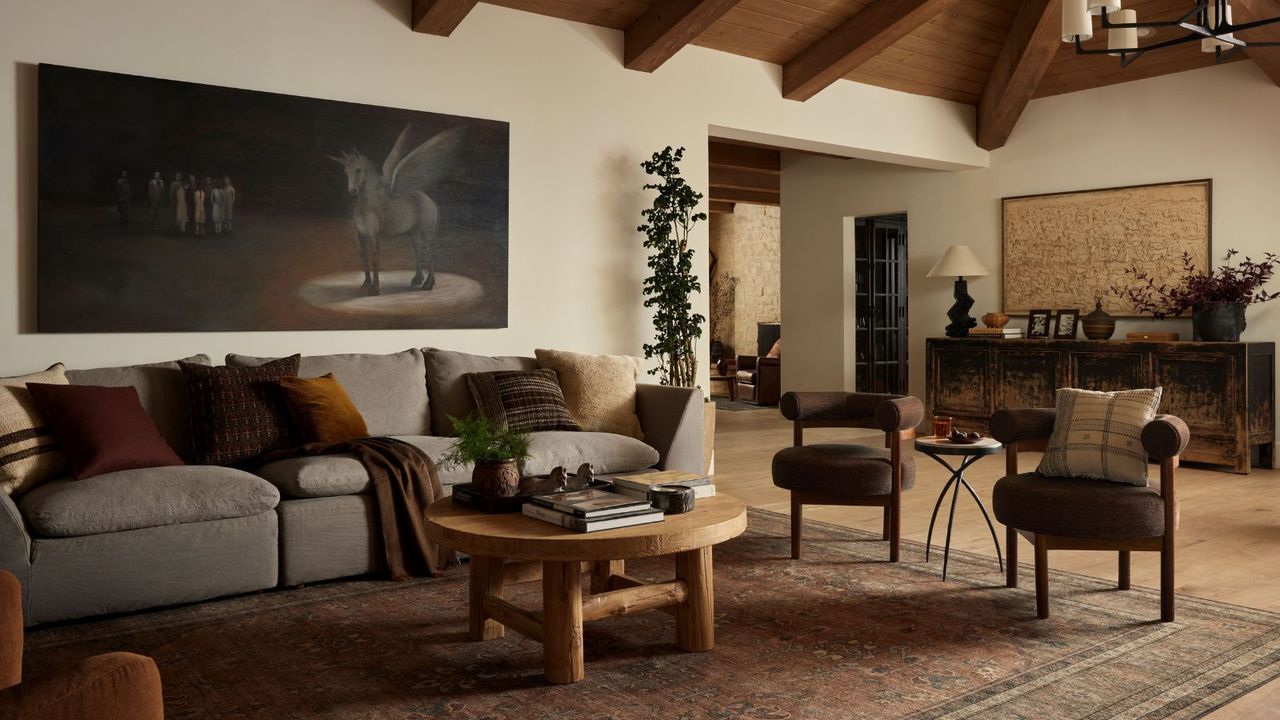 neutral living room with large patterned rug, gray sofa and wooden coffee table